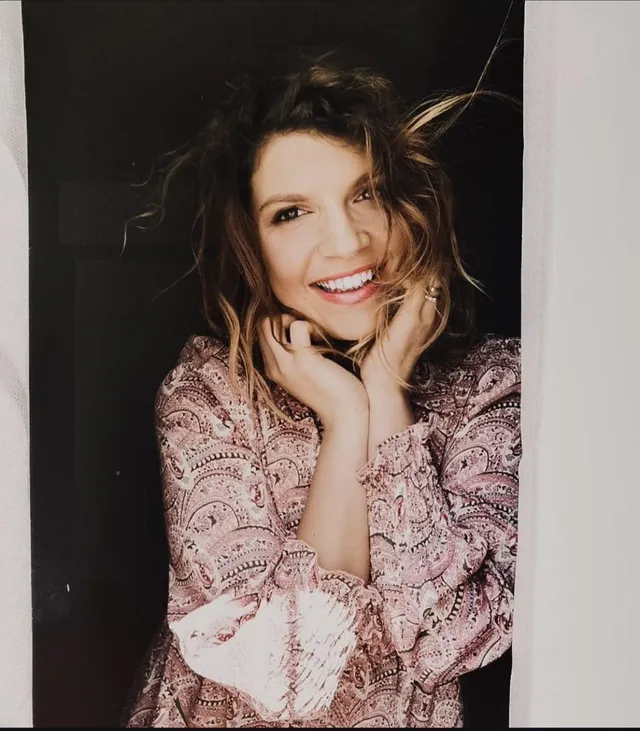 Ritratto di Laura Rubino sorridente sulla soglia di una porta